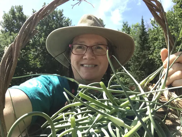 Heather with a basket of garlic scapes